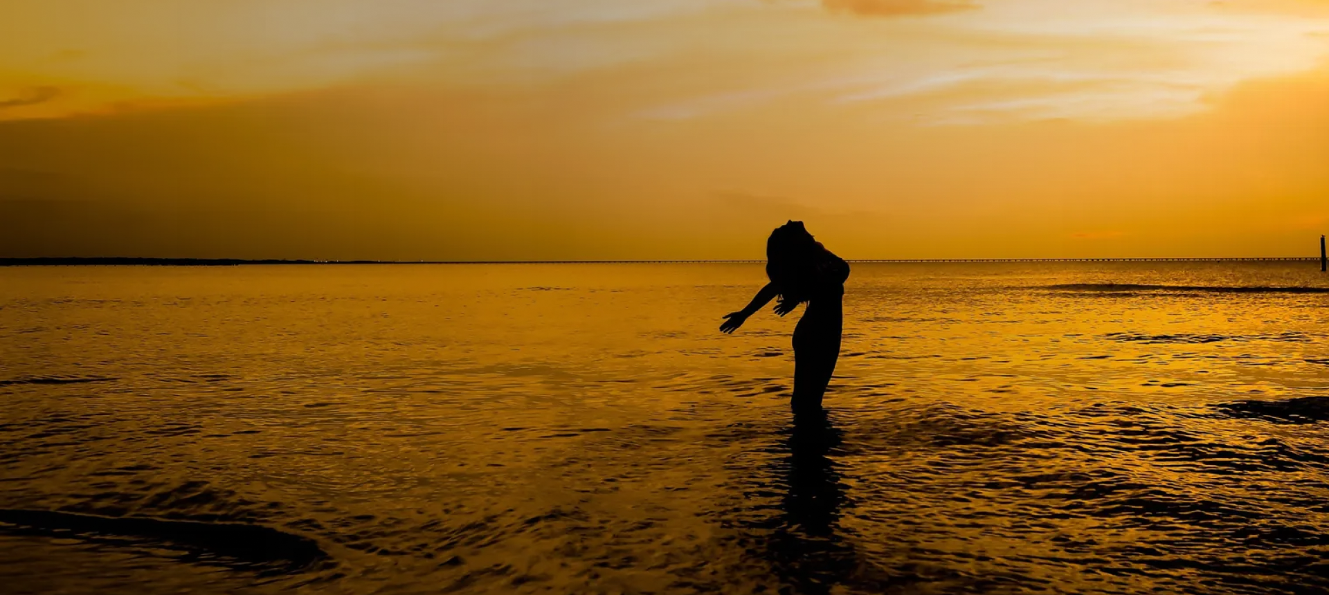 Silhouette of person at sunset beach